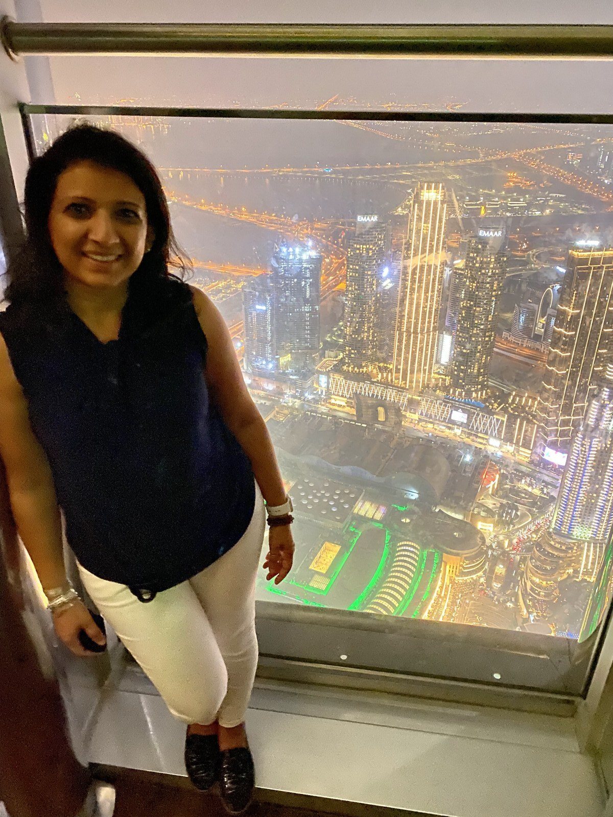 Rashmi on a glass observation floor above Dubai at night