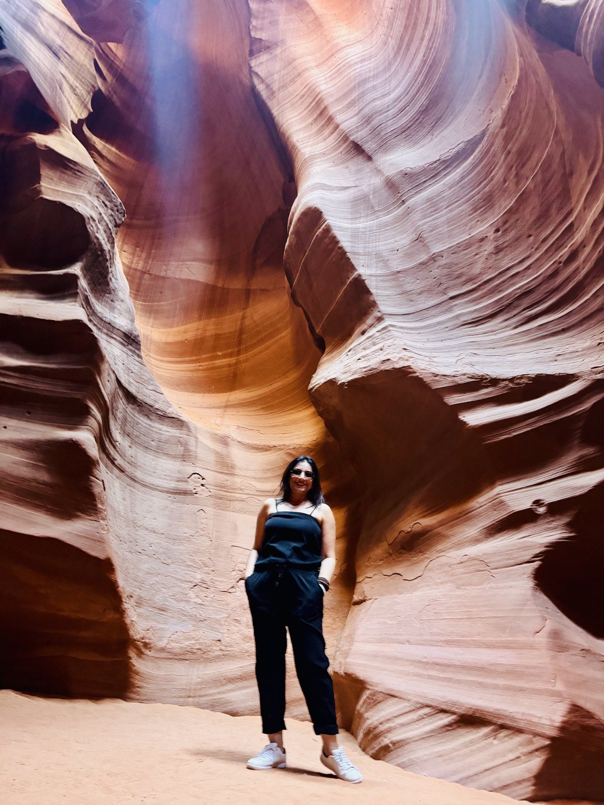 Rashmi standing in a slot canyon lit from above